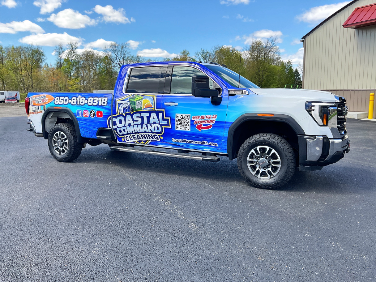 Coastal Command Cleaning pickup with blue water graphics, prominent door branding and a QR code.